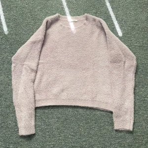 Ljuslila fluffig stickad tröja, KappAhl - Supermjuk och fluffig ljuslila stickad tröja från KappAhl. Tröjan har rund halsringning och långa ärmar, perfekt för att hålla sig varm under kyliga dagar. Enkel och stilren design som är lätt att matcha med olika outfits.