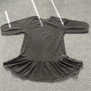 Mörkgrå volangklänning från Ü - Superskön mörkgrå klänning från Ü med volangkant nertill och trekvartsärmar. Tillverkad i mjuk bomull och har en avslappnad passform. Materialet är lite tjock. Perfekt för dig som gillar en enkel men ändå snygg stil. 