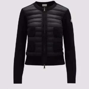 Svart cardigan jacka från Moncler - Snygg svart cardigan jacka från Moncler med quiltad front och stickade ärmar. Jackan har rund hals, dragkedja framtill och fyra stickade fickor på bröst och mage. Perfekt för dig som vill ha en stilren och exklusiv look med sportig touch.