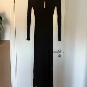 Svart långärmad maxiklänning från Skims - Supersnygg svart långklänning från Skims med lång ärm och rundad urringning. Klänningen är ribbad och har en tight passform. Man får själv stå för frakt.