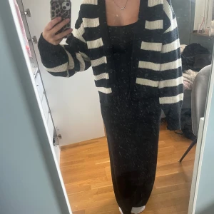 Randig svartvit kofta från H&M - Säljer en stickad kofta från H&M i svart och vitt med breda ränder. stora knappar framtill och en lite loose passform. Perfekt att slänga över en klänning eller t-shirt.
