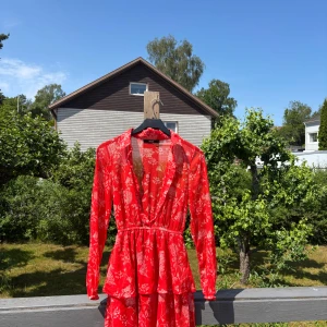 Röd blommig klänning - Röd blommig klänning från bikbok, storlek xs. Passar mig som är s i tröjor, m i byxor!