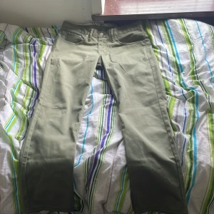 Levi's 511 olivgröna jeans W34 L30 - Snygga olivgröna Levi's 511 jeans med klassisk femficksdesign och raka ben. Jeansen har en slim passform och är tillverkade i bomullstyg med en lätt stretch. Perfekta för dig som gillar en stilren look med lite edge.