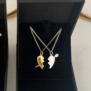 Arrow heart halsband  - Två matchande silver och guld halsband  med delade hjärthängen – perfekta att dela med en vän eller partner. Halsbanden är 100 % rost- och nickelfria. Kedjorna är 40 cm långa men kan förlängas med ytterligare 5 cm. Hör gärna av dig om du har några frågor ☺️ 