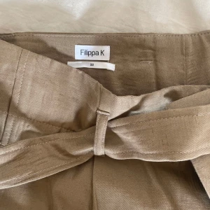 Linnebyxor Filippa K - Linnebyxor från Filippa K. Bruna/beigea i storlek 32. Ansvönda ett par gånger. 