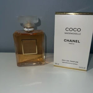 Chanel Coco Mademoiselle EdP 100ml - Chanel Coco Mademoiselle Eau de Parfum 100ml med elegant, fyrkantig glasflaska och frostad lock. Parfymen har en varm bärnstensfärgad vätska och kommer i en stilren vit kartong med guldiga detaljer. En ikonisk och lyxig doft från Chanel.