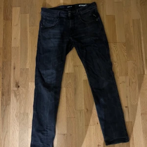 svarta Replay jeans slim fit - Snygga svarta jeans från Replay med klassisk femficksdesign. Jeansen har smal passform och raka ben, perfekt för en clean och modern look. Tillverkade i mjukt denimtyg med stretch för extra komfort.