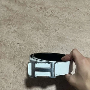 H bälte vit - Säljer ett riktigt fint h bälte i vit som även går att göra till svart, 105 cm. Vid frågor och intresse är det bara och skriva.