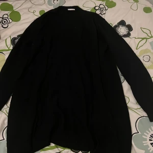 Svart stickad tröja från Vila - En svart öppen stickad tröja från Vila i storlek M. Tröjan har en klassisk rund halsringning och långa ärmar. Enkel att matcha med olika outfits. 
