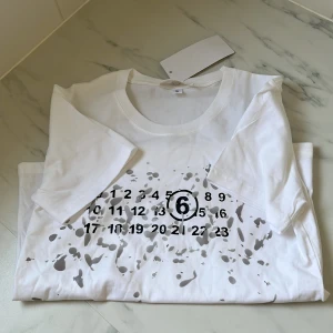 Maison margiela t shirt  - En riktigt fräsch tröja från Maison margiela helt ny lappar är på och oanvänd den är i storlek S och sitter liten i storleken. Säljer den för 699 hör av er om funderingar