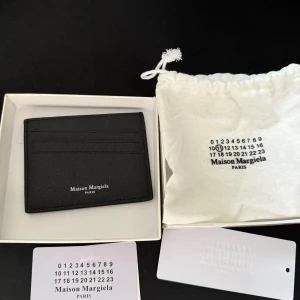 Maison Margiela Plånbok - Maison Margiela korthållare/card holder. Den absolut nyaste modellen, unik och läcker design, medföljer box och alla tillbehör, Helt ny och oanvänd. Priset kan eventuellt diskuteras.
