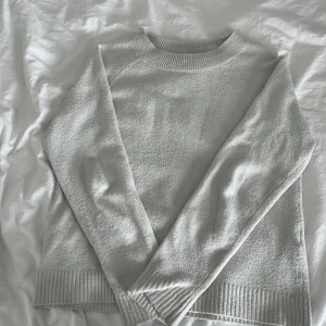 Ljusgrå stickad tröja - Supermjuk ljusgrå stickad tröja från Vero Moda i storlek XS. Tröjan har rund halsringning, ribbade muddar och är långärmad. Perfekt för lager-på-lager och chill dagar. Enkel och stilren design som funkar till allt.