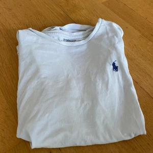Polo ralph Lauren t-shirt - Vit T-shirt från Polo Ralph Lauren med klassisk logga på bröstet. Snygg basmodell som funkar till allt.  Storlek: small Nypris: varierar lite men jag köpte den för 900 kr  Skicket är okej, det finns tecken på användning men inga missfärgningar som är syns väl. Annars är den bra bevarad.