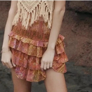 Volangkjol från zara - Superfin kort volangkjol med bohemiskt mönster i gult, orange och rosa toner. Kjolen har flera lager volanger och smock i midjan för en bekväm passform. Storlek S passar även XS!