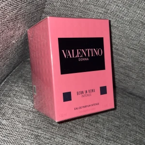 Valentino Donna Born In Roma Intense 100ml - Parfymen Valentino Donna Born In Roma Intense kommer i en snygg rosa kartong med svarta detaljer. Flaskan rymmer 100 ml eau de parfum intense och är perfekt för dig som gillar lyxiga och feminina dofter. Förpackningen har en modern och trendig design.