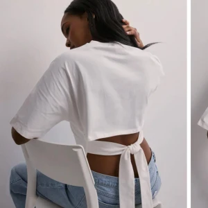 Vit croppad topp med knyt i ryggen - Säljer en vit croppad topp med korta ärmar och snygg knytning i ryggen. Aldrig använd lapp och allt kvar 🥰