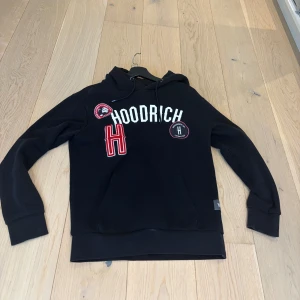 Svart hoodie från Hoodrich med tryck - Svart hoodie från Hoodrich med vit och röd storlek S mycket bra skick!