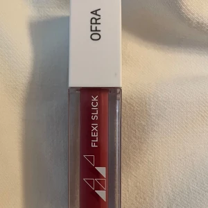 *NY*OFRA Flexi Slick ”Shaken” läppglans, 3,5 ml, Presenttips  - OFRA Flexi Slick i nyansen Shaken är ett läppglans med en mjuk, bärig rosa färg. Ger en glansig finish och känns lätt på läpparna.