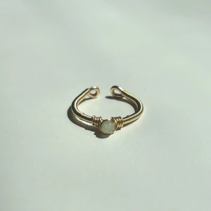 New Jade Ring - Denna ring är tillverkad för hand med rostfri ståltråd som gör den både slitstark och rostfri. Ringen är justerbar för att passa perfekt på de flesta fingrar och pryds av pärlor i äkta New Jade – vilket ger ett naturligt och harmoniskt uttryck. Den är dessutom vattentålig och passar utmärkt för vardagsbruk.