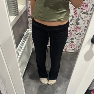 Svarta mjukisbyxor med snörning - Svarta mjukisbyxor med elastisk midja och snörning framtill. Byxorna har en enkel och clean look, perfekta för chill dagar eller när du vill vara bekväm. Använt endast en gång. Går att välja mellan höj eller låg midja väldigt enkelt 😍