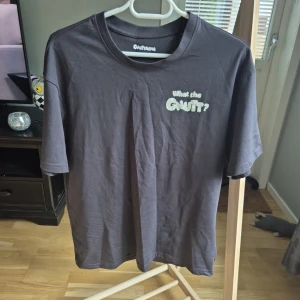 Svart t-shirt Gnutarna XS - Svart t-shirt från Gnutarna i storlek XS med tryck fram som säger 'What the GNUT?' och en stor bild på baksidan med en tecknad figur och texten 'I'm on a seafood diet. I see food, and I eat it.' Skön passform och klassisk rund hals. Köpt på Grönan för 399kr oanvänd!