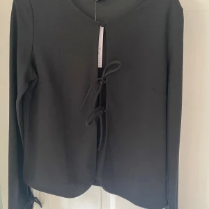 Blus - Fin tröja med rosetter, aldrig använd.