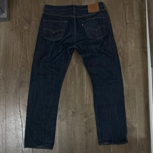 Levis 501  - Levis 501 jeans i mycket bra skick. Jeansen är sparsamt använda och inga tecken på användning. Jeansen är av rådemin och passar bra att bära till vardags men också vid festliga tillfällen. Storleken är W34 L32 och är Straight Leg. Vid frågor eller funderingar tveka inte på att höra av dig!