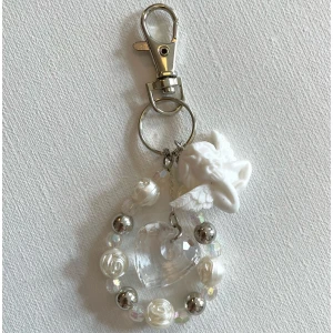 Pärlig ängel- och hjärta bag charm/ nyckelring  - Superfin bag charm med vita pärlor, silvriga kulor, en genomskinlig hjärtberlock och en söt ängel i vitt. Perfekt att hänga på väskan för en dreamy och unik look. Karbinhake i silverfärg gör det enkelt att fästa. Ger en extra touch till din outfit!