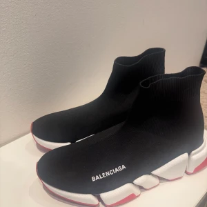 Balenciaga Speed Trainer sneakers - Svarta Balenciaga Speed Trainer sneakers med vit logga på sidan, chunky vit och röd sula och strumpliknande ovandel i stretchigt syntetmaterial. Snygg futuristisk vibe och superbekväma att bära hela dagen.