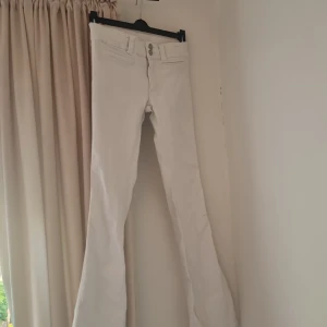 Vita bootcut jeans från H&M - Snygga vita bootcut jeans från H&M i storlek 164. Byxorna har låg midja och justerbar midja för perfekt passform. Tillverkade i bomull med klassiska fickor och stilren look. Perfekta för dig som vill ha en fräsch och trendig vibe.