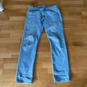 Levi's 501 ljusblå jeans straight fit - Klassiska Levi's 501 jeans i ljusblå tvätt med raka ben och normal passform. Jeansen har fem fickor, knappgylf och ikonisk läderpatch bak i midjan. Perfekta för en avslappnad och tidlös look. Storlek W31 L32. Skriv vid frågor! Pris går att diskuteras