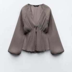 Grå plisserad blus från Zara - Supersnygg slutsåld blus från Zara i storlek XS, den är aldrig använd då jag säljer den för den inte kommer till användning❣️