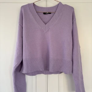Ljuslila stickad v-ringad tröja Bik Bok - Superfin ljuslila stickad tröja från Bik Bok med v-ringning och bred ribbad kant nedtill och vid ärmsluten.