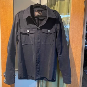 Navy overshirt från Oscar Jacobson - Snygg overshirt från Oscar Jacobson. Perfekt för lager-på-lager-stil. Den har en klassisk krage. Hör av dig vid intresse och frågor!💯