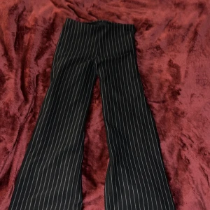 Svarta randiga byxor från Kappahl - Snygga svarta byxor med vita ränder från Kappahl. Byxorna har en klassisk bootcut passform. Säljer då det är för korta. Jag är 167 ungifär❤️🤗