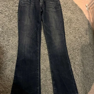 Levis Bootcut Skinny Jeans - Snygga mörkblå Levis jeans i modellen Bootcut Skinny. De har en modern midja och klassiska bakfickor med Levis logga. Perfekta för en stilren look. Midjemåttet är 70!