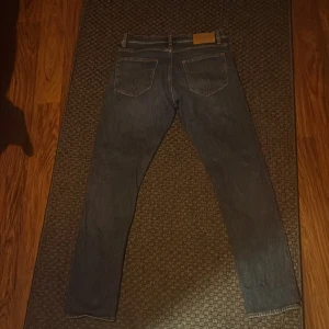 Blå jeansbyxor - Snygga blå tiger of sweden jeans med klassisk design. De har en rak passform 