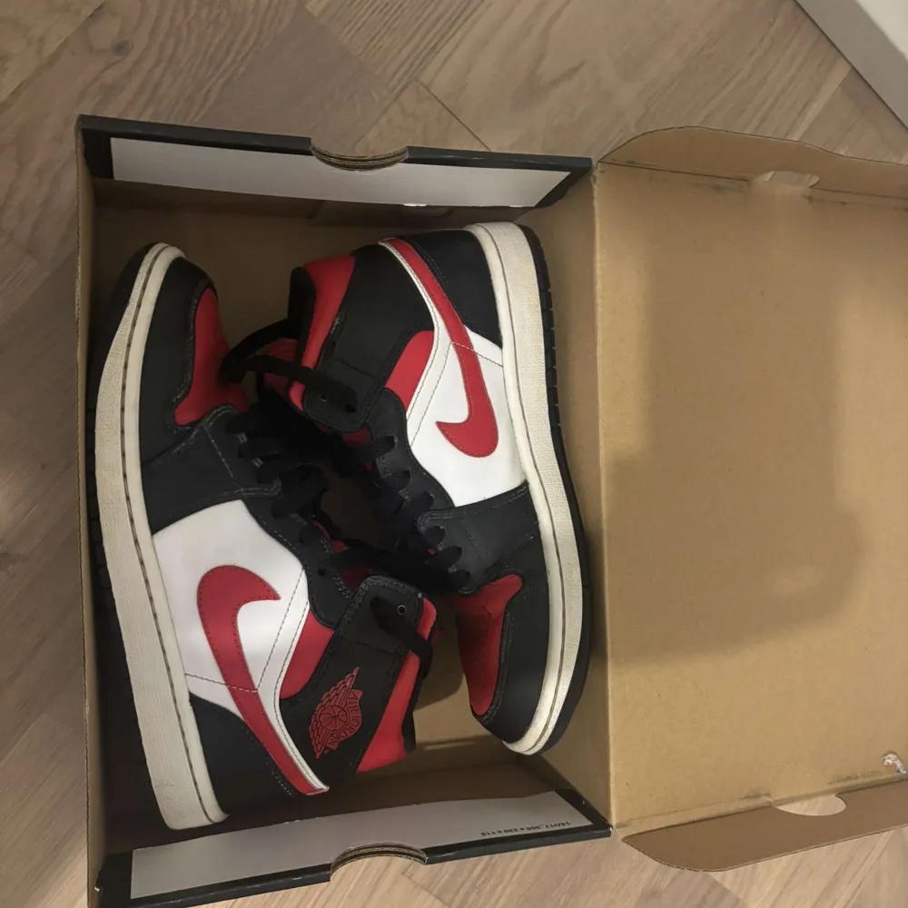 Säljer ett par klassiska Nike Air Jordans i en snygg färgkombination av rött, svart och vitt. Skorna har den ikoniska Air Jordan-loggan på sidan och snörning framtill. Perfekta för dig som vill ha en stilren och sportig look.. Kengät.