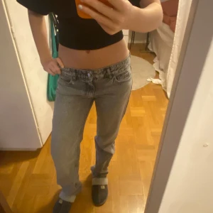 Grå jeans med låg midja - Snygga grå jeans med en klassisk look och låg midja. De har en rak passform och är perfekta för en avslappnad stil. Jeansen har knappar och dragkedja framtill.
