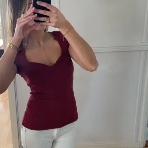 Vinröd ribbad topp  - Vinröd ribbad topp från Anna Field med korta ärmar och v-ringning. I stl XS och har en figursydd passform💞