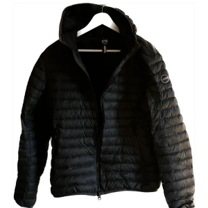 Dunjacka från Colmar - Säljer en stilren dunjacka från Colmar i färgen Antarcit. Jackan har en praktisk huva och dragkedja framtill. Perfekt för kyliga dagar med sin quiltade design som håller värmen. En klassisk och tidlös modell som passar till det mesta. Skriv för fler frågor!😃