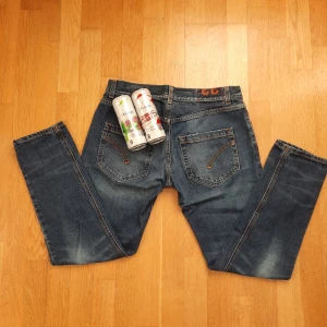 Mörkblåa jeans från dondup - Snygga blå jeans från dondup med klassisk femficksdesign och knappgylf. Jeansen har en slimfit passforml. De har en lätt tvättad look utan större skador. Jeansen är storlek w33 och 97cm i längden vilket ugnefär motsvarar 30 i längd. Känn er fria att komma privat för frågor! Två celsius ingår!