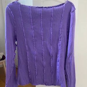 Lila tröja från Monki - Så cool lila ribbad topp från Monki med långa ärmar och vågiga kanter💜Aldrig använt men utan prislapp. 