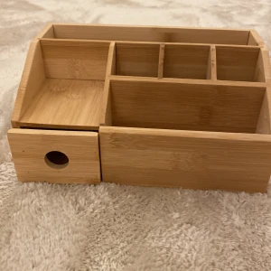 Makup organiser/Bambulåda med fack och utdragbarlåda - Aldrig använd köpt för 300. Praktisk trälåda med flera fack och en utdragbar låda. Perfekt för att organisera småsaker på skrivbordet eller i hemmet. Tillverkad i bambu med en naturlig finish.