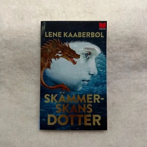 Skämmerskans dotter - Säljer boken 'Skämmerskans dotter' av Lene Kaaberbøl, utgiven av En bok för alla. En spännande fantasyberättelse om Dina som ärvt sin mors gåva att se människors skam. Perfekt för dig som älskar magi och äventyr!