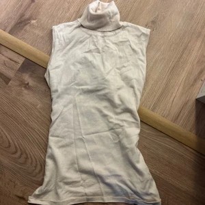 Vit ärmlös polotopp - Säljer en stilren vit ärmlös polotopp i mjukt material. Perfekt för lager-på-lager eller som den är. Passar både till kostymbyxor, jeans och kjol för en chic look. Den är lite skrynklig på bilden men verkligen sååå snygg topp!!!💕
