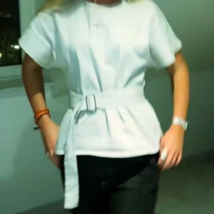 Vit blus med bälte - Säljer denna så snygga t shirt, den är ny med pris lapp