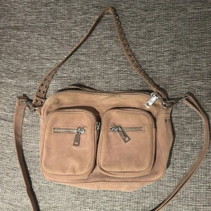 Brun axelväska i mocka - Fin väska från Noella. Näst in till oanvänd så väldigt fint skick!