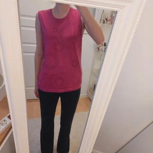 Rosa ärmlös topp med grafiskt mönster - Säljer en rosa ärmlös träningstopp med grafiskt cirkelmönster. Toppen har rund halsringning och är tillverkad i ett mjukt material som känns skönt mot huden. Perfekt för varma dagar eller som lager under en jacka. Är stor Xl men passar även L