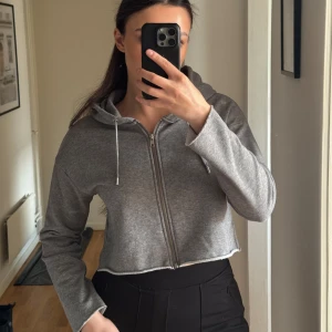 Grå croppad hoodie från Dr Denim - Säljer en grå croppad hoodie/kofta från Dr Denim. Hoodien är i väldigt bra skick och är i storlek xs 🤍